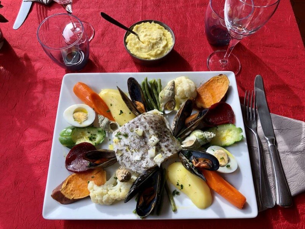 Un plat de poisson et de légumes colorés, dressé sur une assiette carrée
