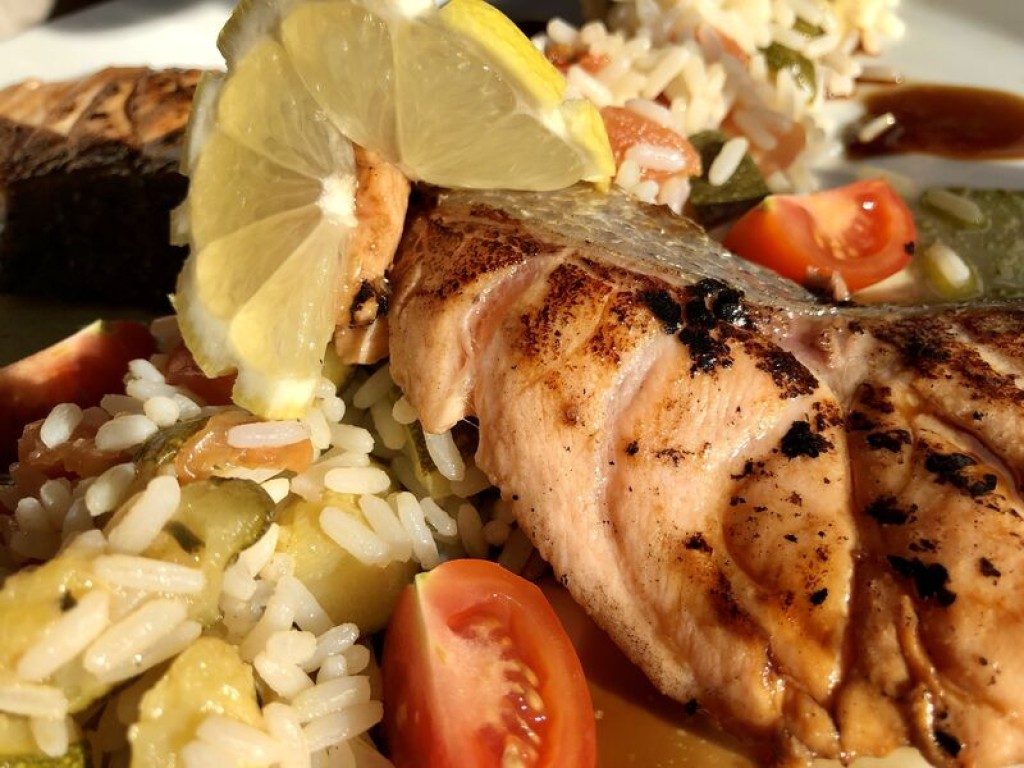Un pavé de volaille grillé sur du riz et des tomates cerises